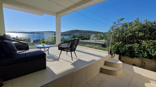 a balcony with a couch and a table and chairs at Sunset Apartment in Sevid