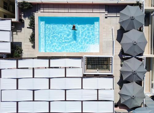 an overhead view of a person swimming in a pool with umbrellas at Ta' Tereza In Manwel Dimech in Sliema