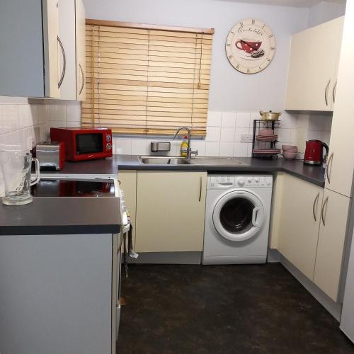 a kitchen with a sink and a washing machine at City apartment in London