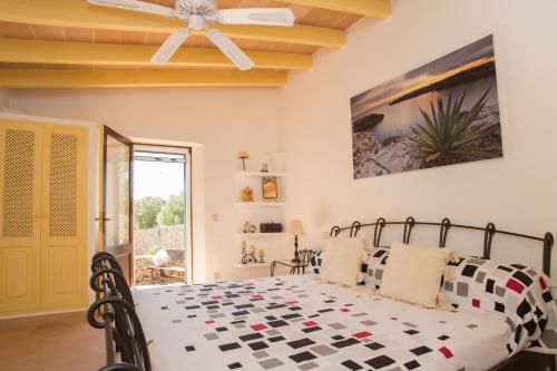 a bedroom with a bed and a ceiling fan at Finca Vallaca in Calonge