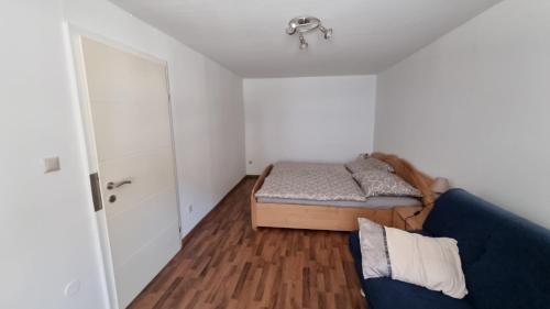 a bedroom with a bed and a blue couch at Villa Theresa Apartments in Mainburg