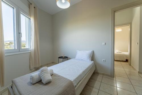 a white bedroom with a bed with towels on it at Joyful Guest Houses by 8essentially in Chania Town