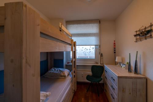 ein Schlafzimmer mit einem Etagenbett und einem Schreibtisch in der Unterkunft Appartement Majelle in Egmond aan Zee