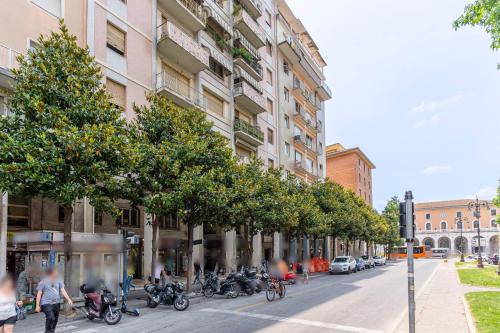 a row of trees on a street next to a building at A Pisa con amore in Pisa