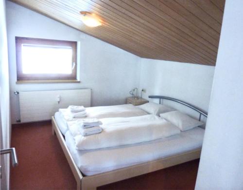a bedroom with a large white bed with a window at St Anton Apartment QX3 in Sankt Anton am Arlberg