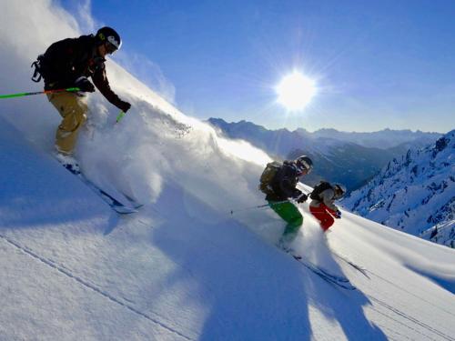 two people skiing down a snow covered mountain at St Anton Apartment QX3 in Sankt Anton am Arlberg