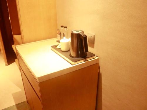 SENNA SUNSHINE INTERNATIONAL HOTEL في سيهانوكفيل: وجود آلة صنع القهوة على طاولة في الغرفة
