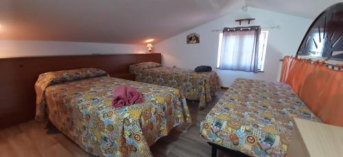 ピエディモンテ・エトネーオにあるFrancesca Home - Relax in Villaのベッド2台とテーブルが備わるホテルルームです。