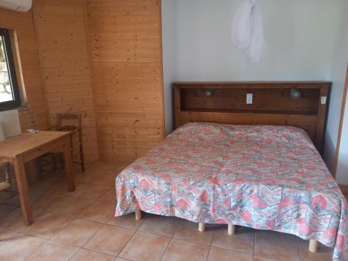 une chambre avec un lit et une table dedans dans l'établissement Les Colombes Vegan, à Aubres