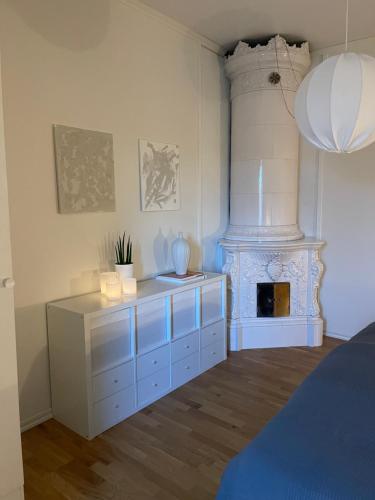 Gröna Huset في تورسبي: غرفة بيضاء مع موقد وسرير
