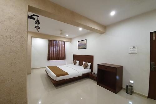 1 dormitorio con 1 cama y vestidor en Hotel Montana NX, en Lonavala