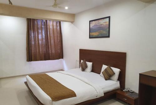 ein Schlafzimmer mit einem großen Bett in einem Zimmer in der Unterkunft Hotel Montana NX in Lonavla