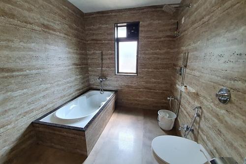 Un baño con bañera y WC. en Hotel Montana NX, en Lonavala