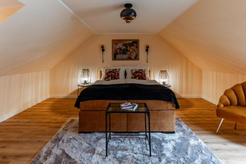 een slaapkamer op zolder met een bed en een bank bij Juwel am Meer - Smaragd in Bad Zwischenahn