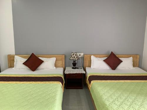 two beds sitting next to each other in a room at ĐÔNG ĐÔ HOTEL Đăk Lăk in Buôn Tâng Mai