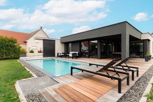 une maison avec une piscine et une terrasse en bois dans l'établissement La Sublime villa avec piscine, à Sainte-Croix-en-Plaine