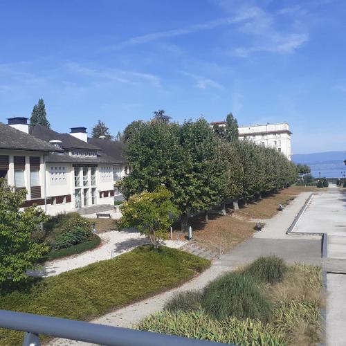 a row of trees in front of a building at CHARMANT APPARTEMENT à 150 M des THERMES et du CENTRE VILLE in Thonon-les-Bains