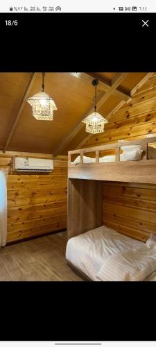 a bedroom with two bunk beds and two lights at القصر الريفي in Al Khafji