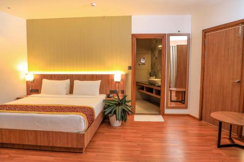 1 Schlafzimmer mit einem großen Bett und einem Badezimmer in der Unterkunft Hotel Sky Sierra Wayanad in Kalpatta