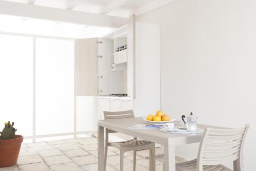 ein weißes Esszimmer mit Tisch und Stühlen in der Unterkunft Costa Azzurra Gallipoli in Gallipoli