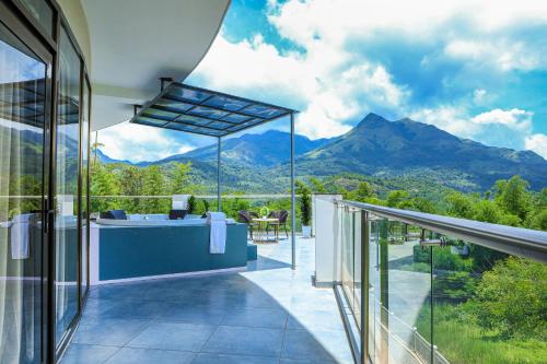 a balcony of a house with a view of mountains at Hotel Sky Sierra Wayanad in Kalpetta