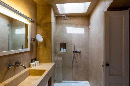 uma casa de banho com um chuveiro, um lavatório e um espelho. em Tre Bacili - L'ospitalità in Dimora em Spongano