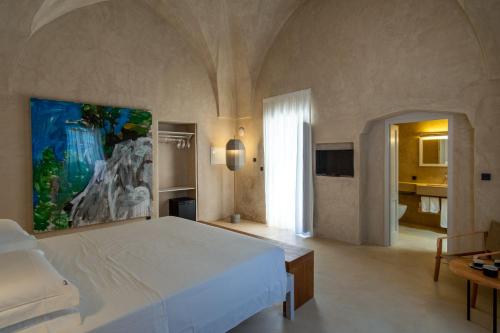 um quarto com uma grande cama branca num quarto em Tre Bacili - L'ospitalità in Dimora em Spongano