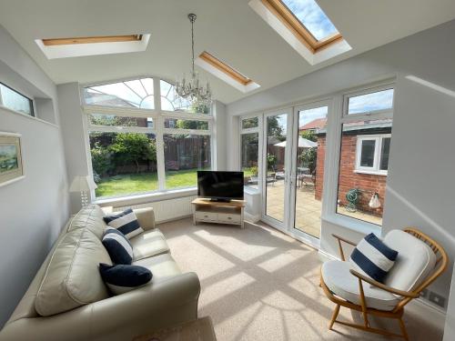 uma sala de estar com um sofá e uma televisão em Seaview House, Tynemouth - Luxury Family Holiday Home em Tynemouth