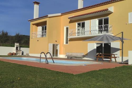 a villa with a swimming pool in front of a house at Casa Souto da Serra in Portalegre