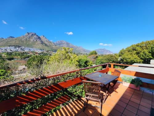 a balcony with a table and chairs and mountains at The Salt House in Hout Bay