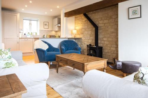 a living room with blue chairs and a fireplace at Mill Village 67, Driftwood Lake House - P in Somerford Keynes