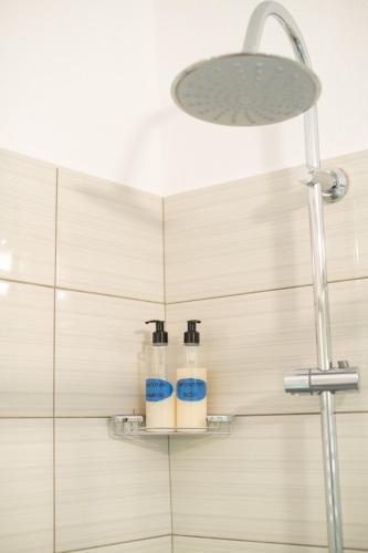 a bathroom with two soap bottles on a shelf at The Florina Park House in Florina