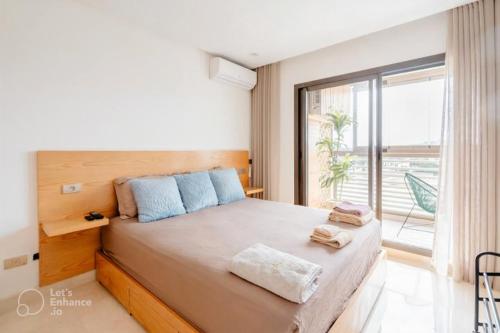 a bedroom with a large bed with a large window at PRESTIGE GHANDI - Studio luxueux & cosy avec terrasse aménagée in Casablanca