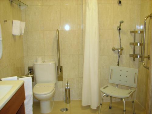 a bathroom with a toilet and a shower at Hotel Apolo in Vila Real de Santo António