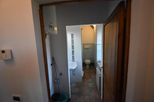 a hallway leading to a bathroom with a sink and a toilet at Falesta in Casole dʼElsa