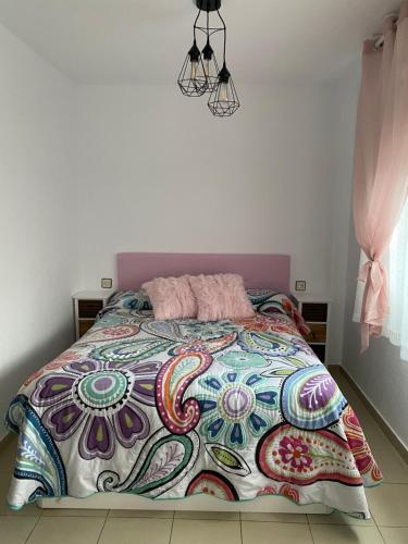 a bedroom with a bed with a colorful comforter at Apartamento sabiñanigo in Sabiñánigo