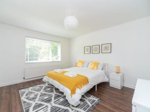 a white bedroom with a bed and a window at Pass the Keys Stylish Apt in quiet cul de sac in Surbiton