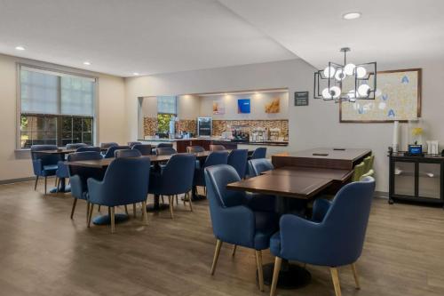 a dining room with tables and blue chairs at Comfort Inn Newport News - Hampton I-64 in Newport News