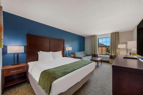 a hotel room with a large bed and a desk at Comfort Inn Newport News - Hampton I-64 in Newport News