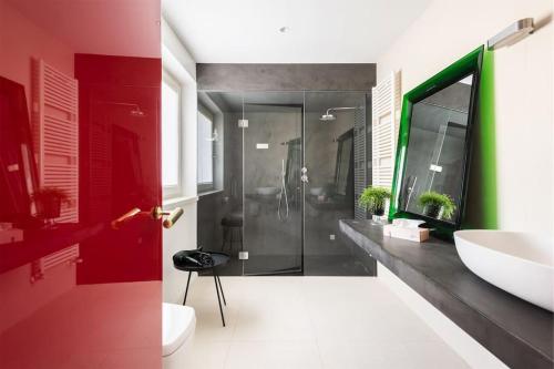 a bathroom with a shower and a red door at Casa tra gli Olivi in Arco