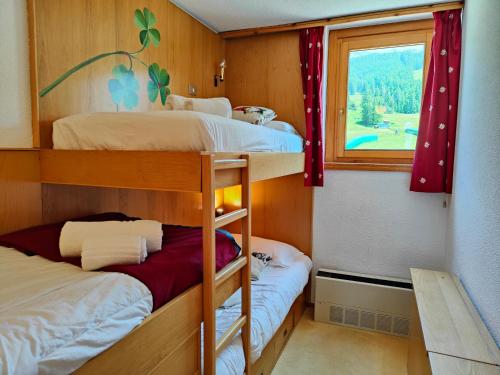 a bedroom with two bunk beds and a window at Hostdomus - Sansicario C 14 in Cesana Torinese