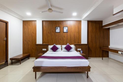 a bedroom with a large bed with wood paneling at Hotel Kalinga in Indore