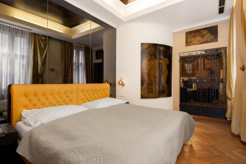 um quarto com uma cama grande e uma cabeceira amarela em Castello Apartments em Viena