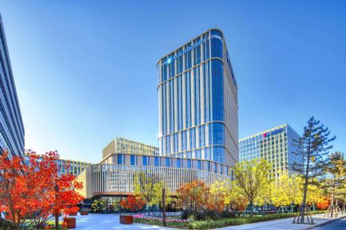 a tall glass building in a city at Wyndham Xiong'an in Baoding