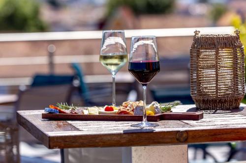 uma mesa com dois copos de vinho e um prato de comida em Best Western Arcachon Le Port em Arcachon