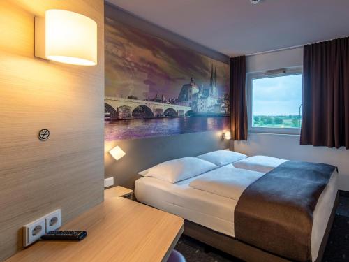 a hotel room with a bed and a window at B&B Hotel Regensburg-City in Regensburg