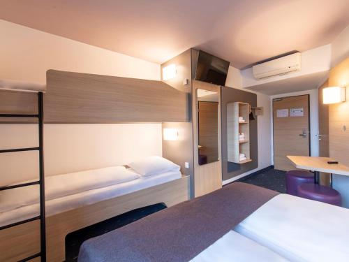 a hotel room with a bed and a desk at B&B Hotel Regensburg-City in Regensburg