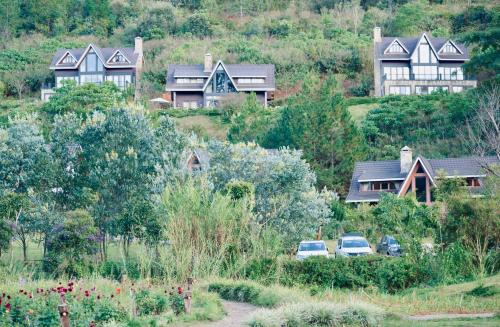 Lat Valley Village في Dankia: مجموعة منازل على تلة مع سيارات متوقفة