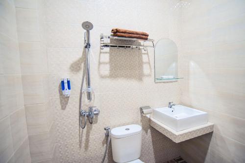 uma casa de banho branca com um WC e um lavatório em Ndalem Mataram em Banyuwangi