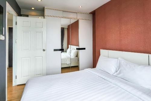 a bedroom with a white bed and a mirror at O2 Hotel Maesot in Mae Sot